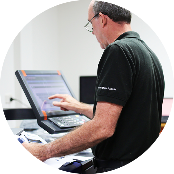 Printer technician works on a screen in workshop