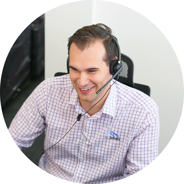 IT Tech wearing headset smiles at desk