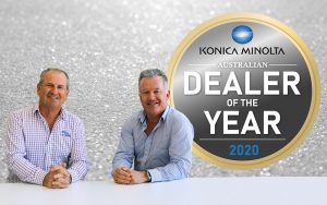 Our History Document Solutions directors Colin and Alan sit smiling, Australian dealer of the year logo behind them