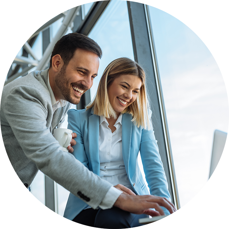 Young man and woman smiling while looking at laptop