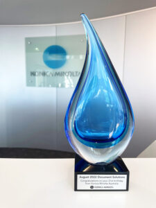 Blue glass drop memento from Konica Minolta sits on DocSol reception desk