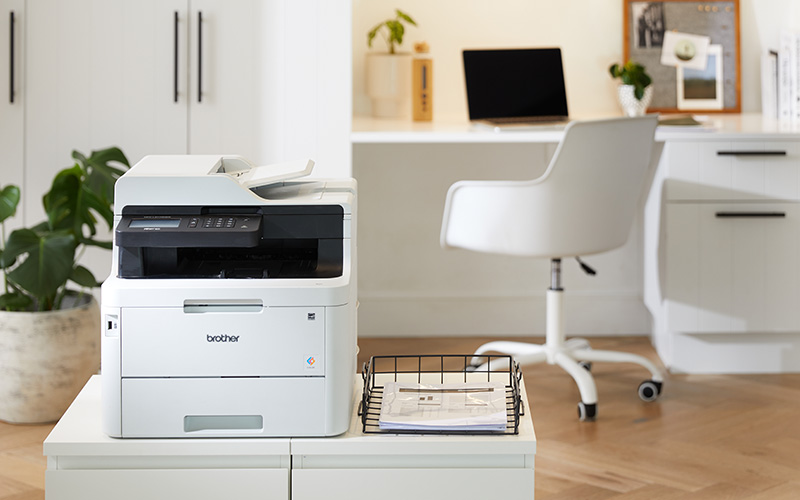 A4 Brother printer sits on a cabinet in a clean, minimalistic home office
