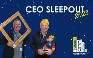 Alan Thompson holds a cardboard frame and Colin Wheeler holds a teddy bear. Text says "CEO SLEEPOUT 2023".