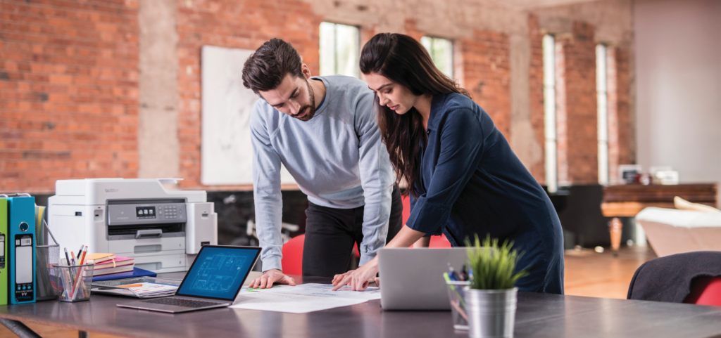 Woman and man working next to an office printer they selected