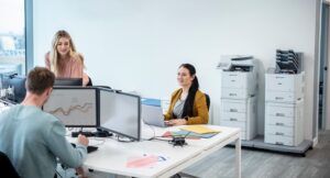 corporate team working in a room with an office printer