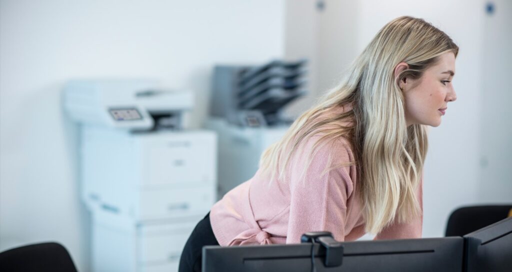 Woman working in front of an office printer