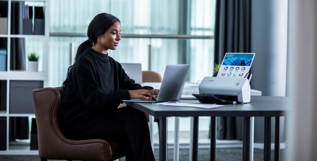 Woman working in office with a brother printer and scanner