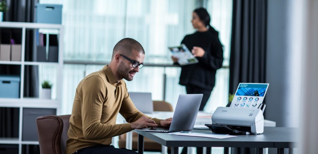 Woman and man working in an office with a brother scanner