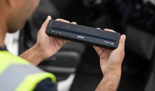 Construction worker holding brother portable printer